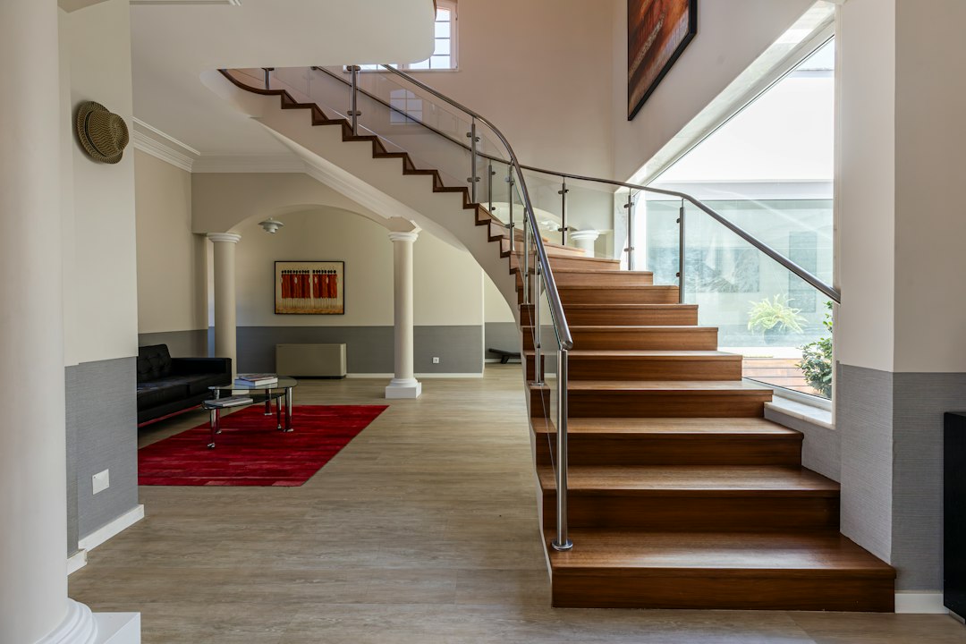 Curved wooden staircase leads to a grand living area