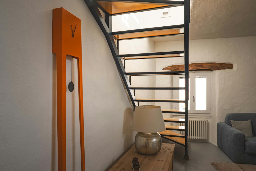 A staircase leads up, near an orange clock